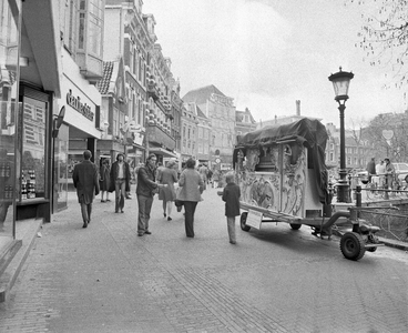857028 Afbeelding van een orgelman met met zijn draaiorgel op de Oudegracht te Utrecht, ter hoogte van de Bakkerbrug.